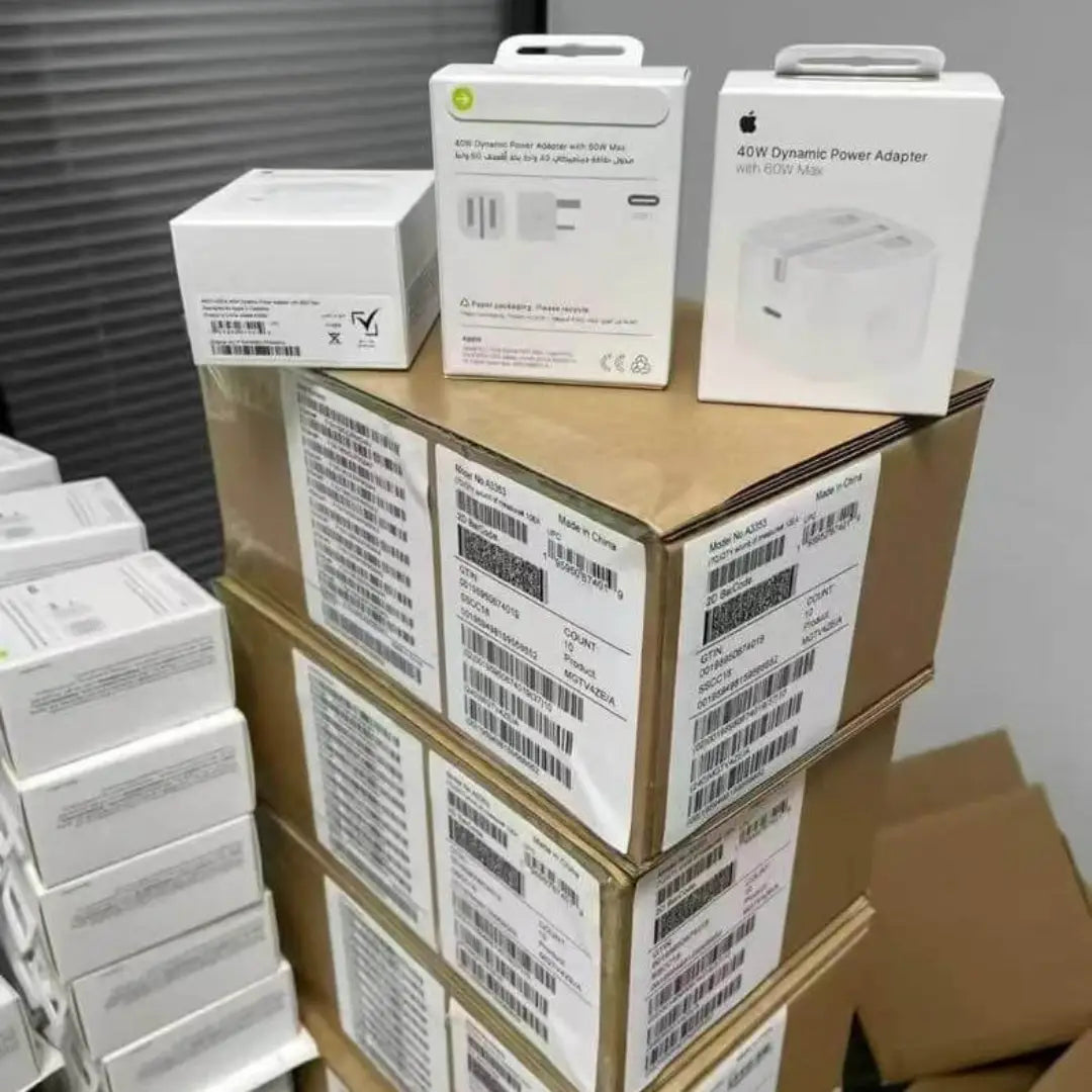 Stack of Apple product boxes with power adapters on a cardboard box.