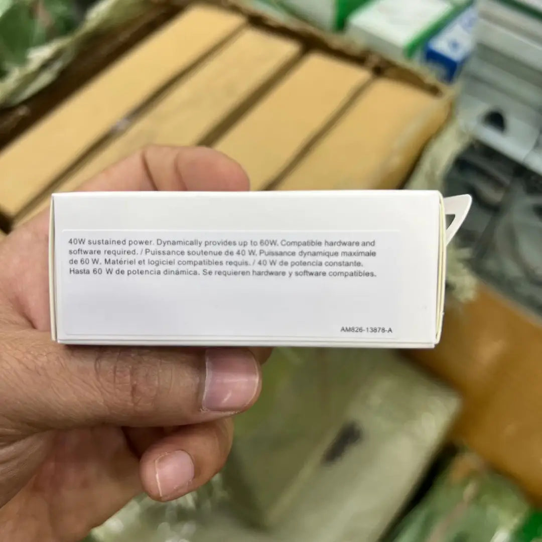 Hand holding a white box with text on a blurred background

