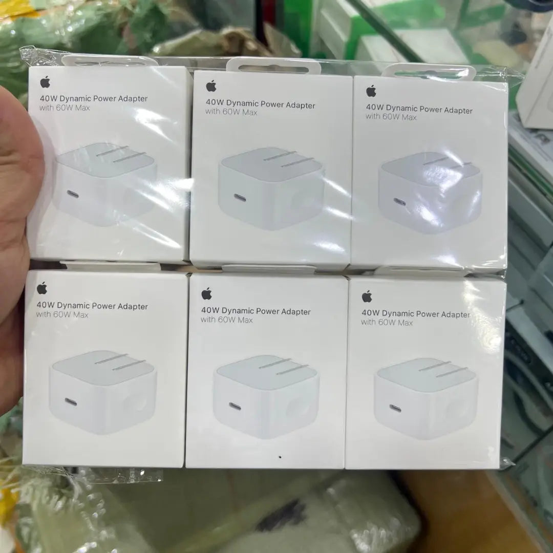 Multiple boxes of 40W Dynamic Power Adapter with Apple logo on a blurred background