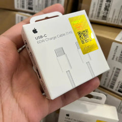 Hand holding an Apple USB-C charge cable packaging with a QR code label.